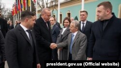 Türkiye prezidenti Recep Tayyip Erdoğan qırımtatarlarnıñ lideri Mustafa Cemilevnen Kyivde Ukrayına prezidenti Volodımır Zelenskıynen körüşkende selâmlaşa, 2020 senesi fevralniñ 3-ü