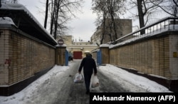 A man carries bags of food toward the entrance of the Lefortovo prison in Moscow.