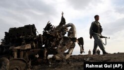 An Afghan security officer at the site of a roadside bomb attack near Bagram Air Base, north of Kabul, on April 9