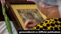 Женщина молится у иконы Пресвятой Богородицы в храме Иоанна Предтечи в городе Керчи. 