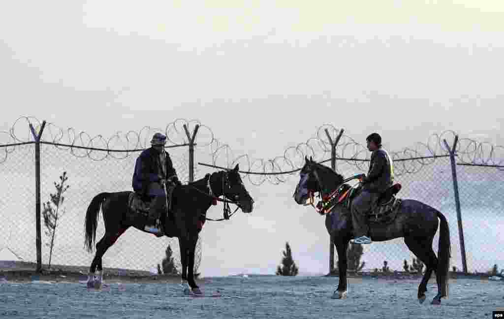 Two Afghans ride horses on the outskirts of Kabul. (epa/Hedayatullah Amid)