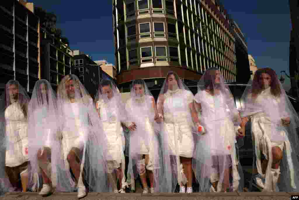 Activists from the Lebanese NGO Abaad (Dimensions), a resource centre for gender equality, dressed as brides and wearing injury patches, protest in downtown Beirut against Article 522 in the Lebanese penal code. The article shields rapists from prosecution on the condition that they marry their victim, a phenomenon that is still practiced in the country, especially among conservative families whose chief aim is to preserve the family's so-called "honor." (AFP/Patrick Baz)