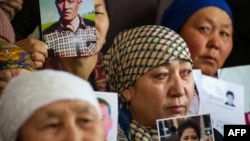 Petitioners with relatives missing or detained in Xinjiang hold up photos of their loved ones during a press event at the office of the Atazhurt rights group in Almaty, Kazakhstan, on January 21, 2019.