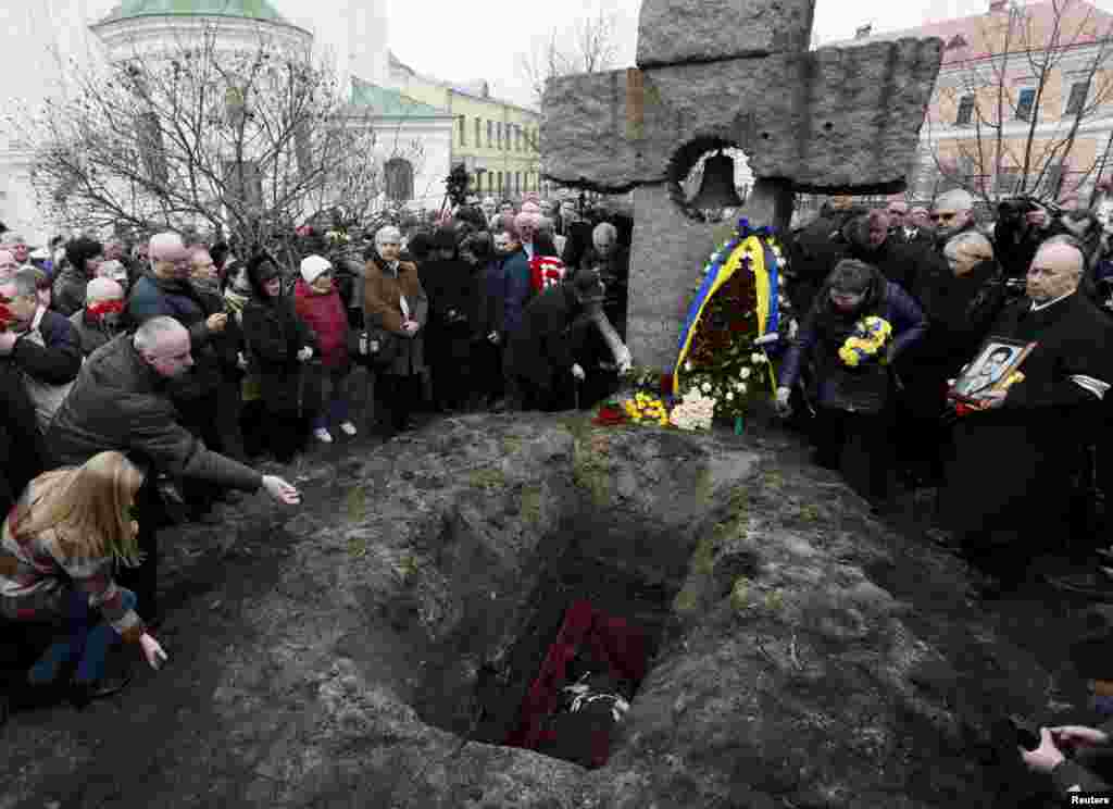 People mourn during the funeral of opposition journalist Georgiy Gongadze, who was killed in 2000, during a funeral ceremony near the Church of Mykola Naberezhny in Kyiv, Ukraine. Gongadze, a dogged investigative journalist who exposed high-level political corruption, was kidnapped in September 2000. His headless body was found that November in a forest outside the capital. His body had been kept in a morgue ever since. Reuters/Valentyn Ogirenko)