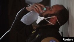 Бунтовник дише од маска со кислород по наводниот хемиски напад во Хан Шејхун