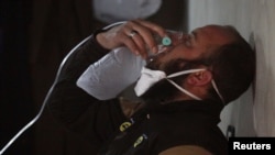 A civil-defense member breathes through an oxygen mask after what rescue workers described as a suspected gas attack in the town of Khan Sheikhun in rebel-held Idlib on April 4.