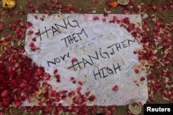 Лист бумаги перед входом в здание атакованной школы в Пешаваре с надписью "Вздерните их сейчас, вздерните их повыше!"