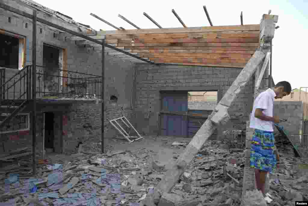 A man stands near a house that was ruined during a special Russian antiterrorist operation in Kaspiysk.