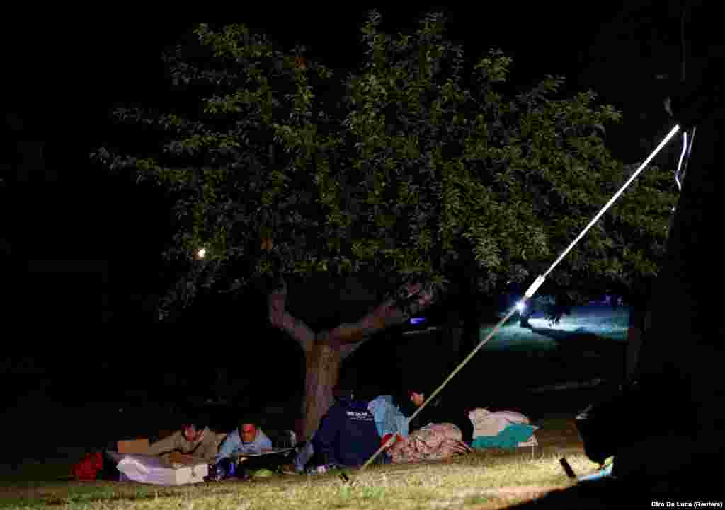 Ljudi spavaju ispod drveta napolju u Amatričeu