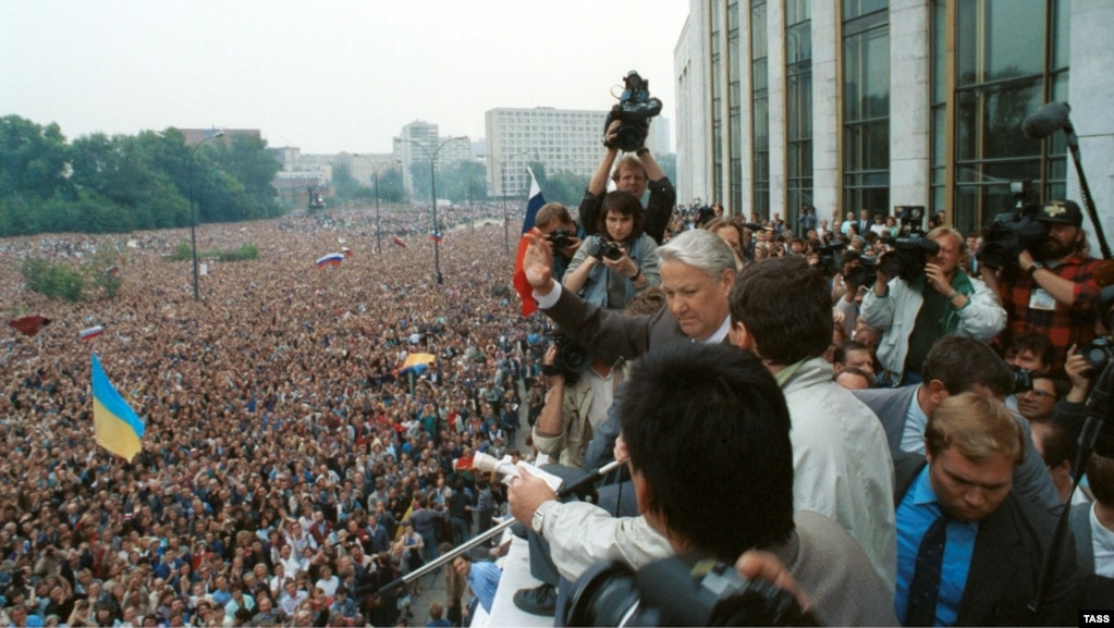 Москва, Росія, 20 серпня 1991 року. Виступ президента РРФСР Бориса Єльцина на мітингу в розпал заколоту «ГКЧП». На мітингу майорять і українські прапори, на передньому плані – синьо-жовтий стяг, а на задньому – червоно-чорний