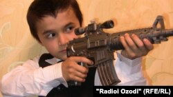 Arxiv foto: Tacikistanda oyuncaq silahı ilə oynayan məktəbli. 29 avqust 2011