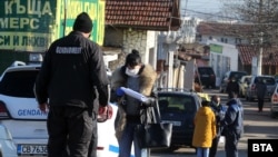 Полицай проверява жена в софийския ромски квартал "Филиповци"