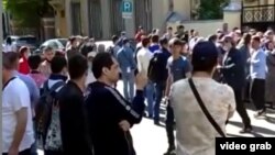 Таджикские мигранты стоят в очереди у посольства РТ в Москве.