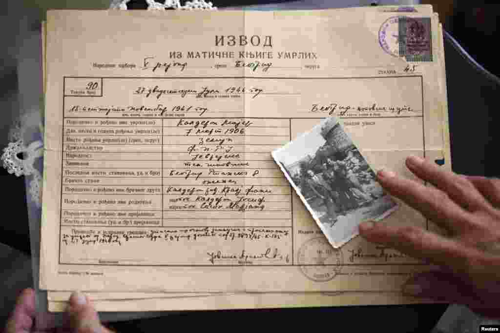 Marijana Sibinovic shows a photograph of her father and his brothers, who were interned in Topovske Supe, on top of her father's death certificate. Some 70,000 Yugoslav Jews died during World War II.