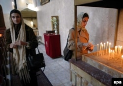 Egy iráni keresztény nő 2003. december 25-én gyertyát gyújt a teheráni örmény templomban, ahol az iráni keresztények, főként örmények ünnepelnek karácsonykor. Az örmény keresztények őshonosnak minősülnek, az áttértek nem