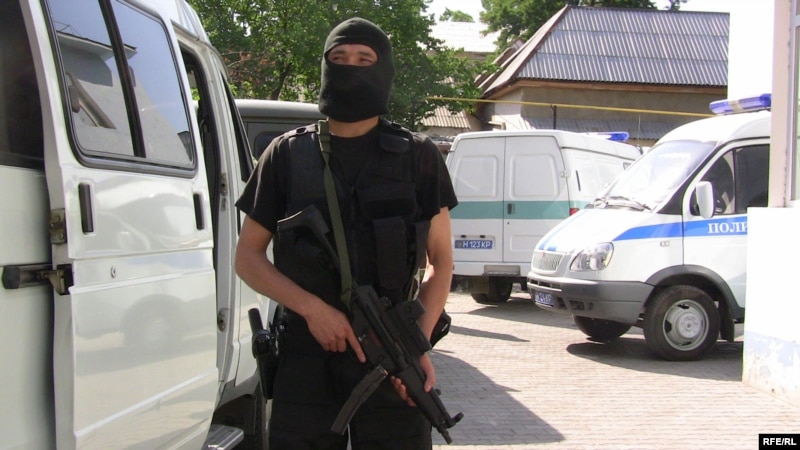 Боец полиции наблюдает за обстановкой на территории суда в день оглашения приговора по делу Султана Махмадова и Рамазана Есергепова. Тараз, 8 августа 2009 года. 