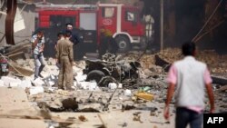 عناصر أمن ورجال إنقاذ يتفحصون موقع إنفجار في كربلاء