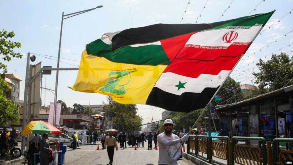 بر افراشتن بیرقی مرک از پرچم‌های ایران، فلسطین، سوریه و حزب‌الله در مراسم روز قدس در تهران در سال ۹۵