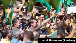 Президент Бразилії Жаїр Болсонару (в центрі кадру в синій сорочці) вітає прихильників під час масової акції, 31 травня 2020 року