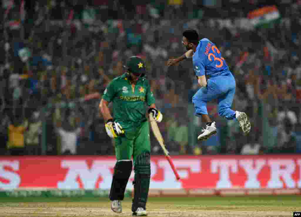 India's Hardik Pandya, right, celebrates after his dismissal of Pakistan captain Shahid Afridi, left, at the Eden Gardens Cricket Stadium in Kolkata on March 19.