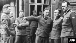 De la stânga la dreapta: Josef Kramer, comandantul lagărului de concentrare Bergen-Belsen; dr. Josef Mengele, cunoscut drept Îngerul Morții; Richard Baer, comandantul lagărului de concentrare Auschwitz I; Karl Hoecker, ofițer în Auschwitz și un ofițer neidentificat.