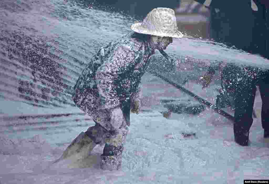 A firefighter is covered with Aqueous Film Forming Foam as he tries to control a fire that broke out in a thinner manufacturing plant on the outskirts of Ahmedabad, India. (Reuters/Amit Dave)