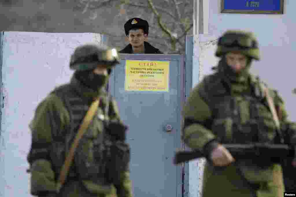 Українські військові частини на території Криму були заблоковані російськими військами. Український солдат із частини в Перевальному визирає з-за паркану, 3 березня 2014 року