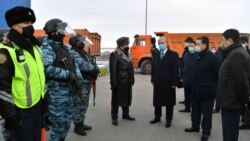 Қазақстан президенті Қасым-Жомарт Тоқаев (ортада) қалаға кіреберістегі өткізу-тексеру бекетіндегі күш құрылымдары қызметкерлермен әңгімелесіп тұр. Нұр-Сұлтан, 19 наурыз 2020 жыл.