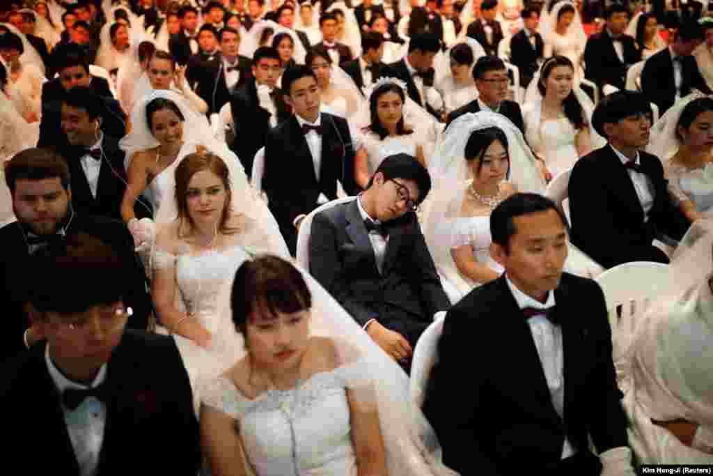 A groom naps as newlywed couples attend a mass wedding ceremony of the Unification Church at Cheongshim Peace World Center in Gapyeong, South Korea. (Reuters/Kim Hong-Ji)