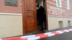 People stand at one of the entrances to the Memorial rights group office in Moscow on March 21.