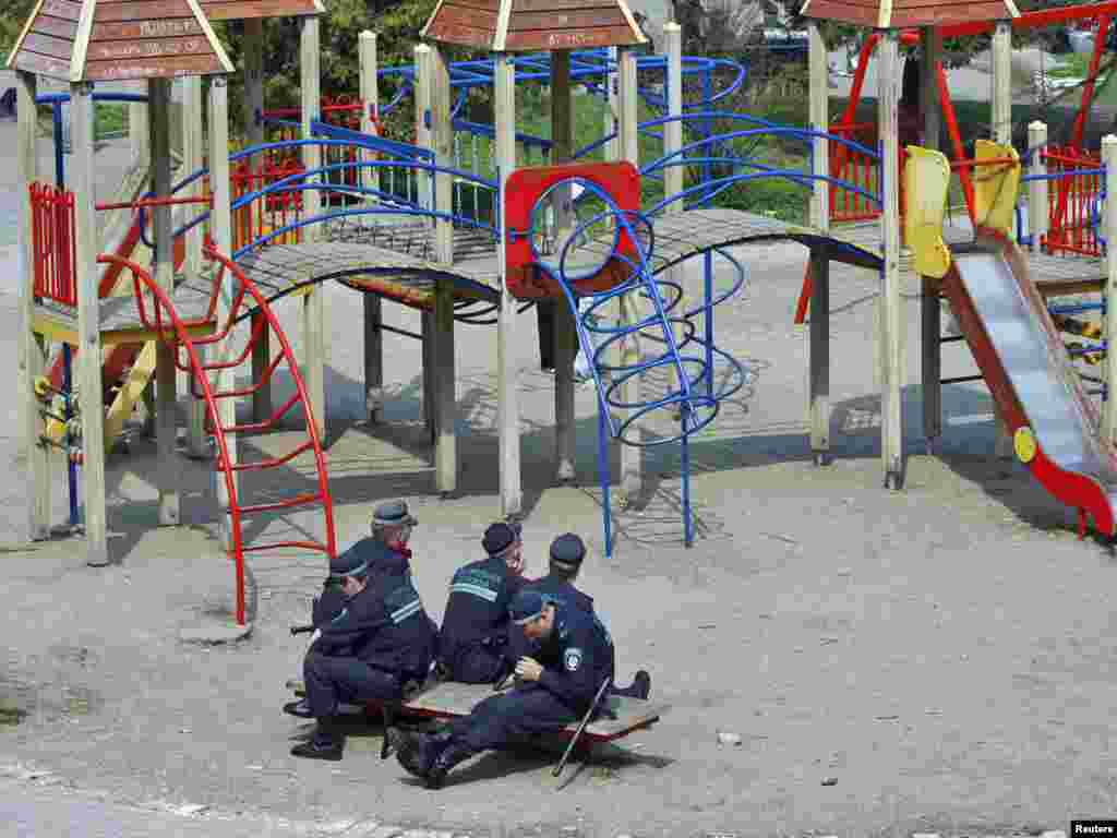 Ukrajina - Dječije igralište bilo je zgodno mjesto za odmor ovim policajcima, Akijev, 27.04.2011. Foto: Reuters / Gleb Garanich 