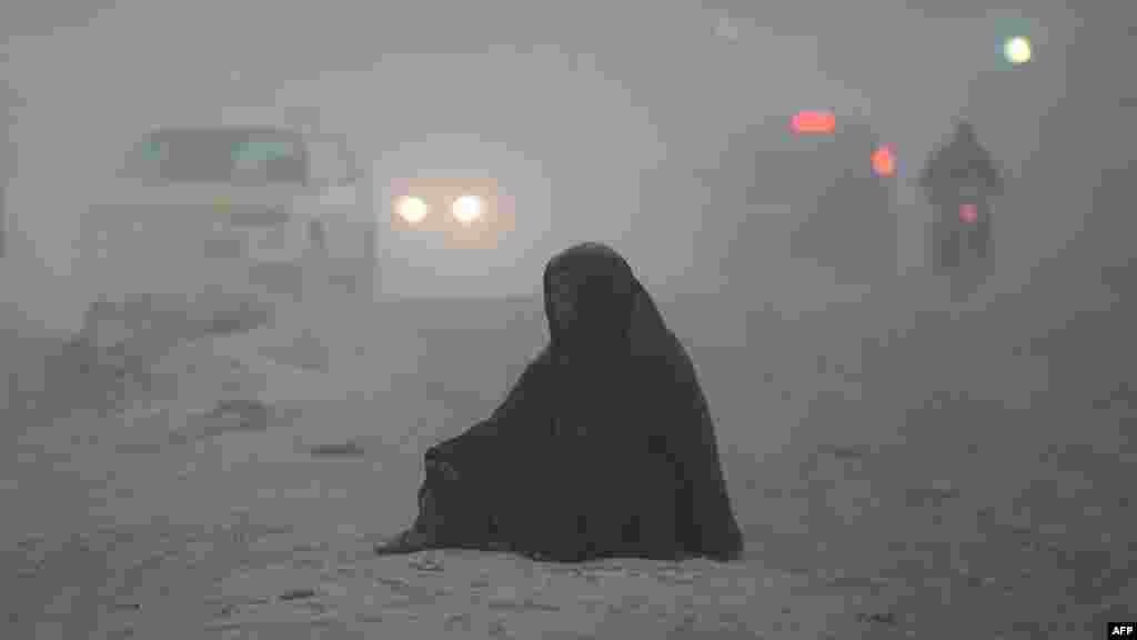 An Afghan beggar waits for alms on a dusty road on the outskirts of Kabul, Afghanistan, on October 17.&nbsp;