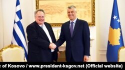 Greek Foreign Minister Nikos Kotzias (left) shakes hands with Kosovar President Hashim Thaci in Pristina on April 12.