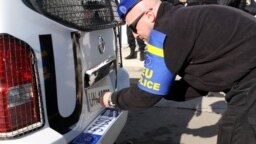 Një polic i EULEX-it duke ndryshuar tabelat nga UNMIK në EULEX