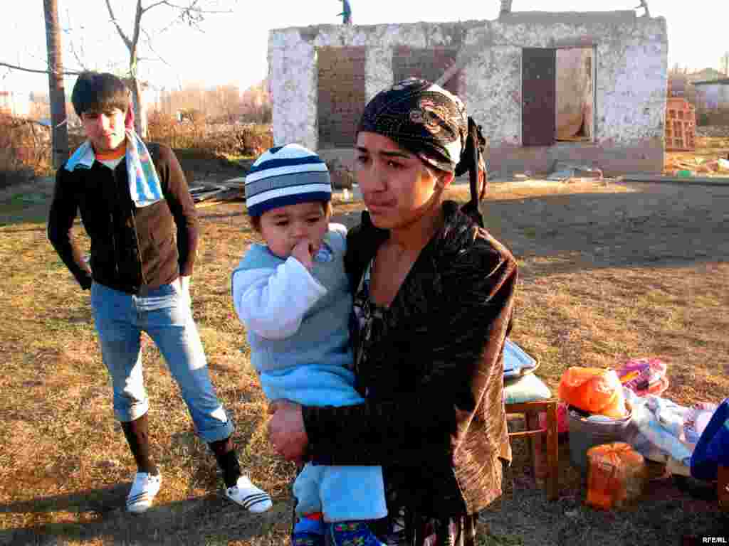 A Tajik family stands outside their home, partially destroyed to make way for a government redevelopment project. - Dozens of families have been forced out of their home in the village of Buni Hisorak near the Tajik capital, Dushanbe, amid plans to redevelop the district. Many have not yet been provided with alternative housing and have no place to go. Photo by Barot Yusufi for RFE/RL
