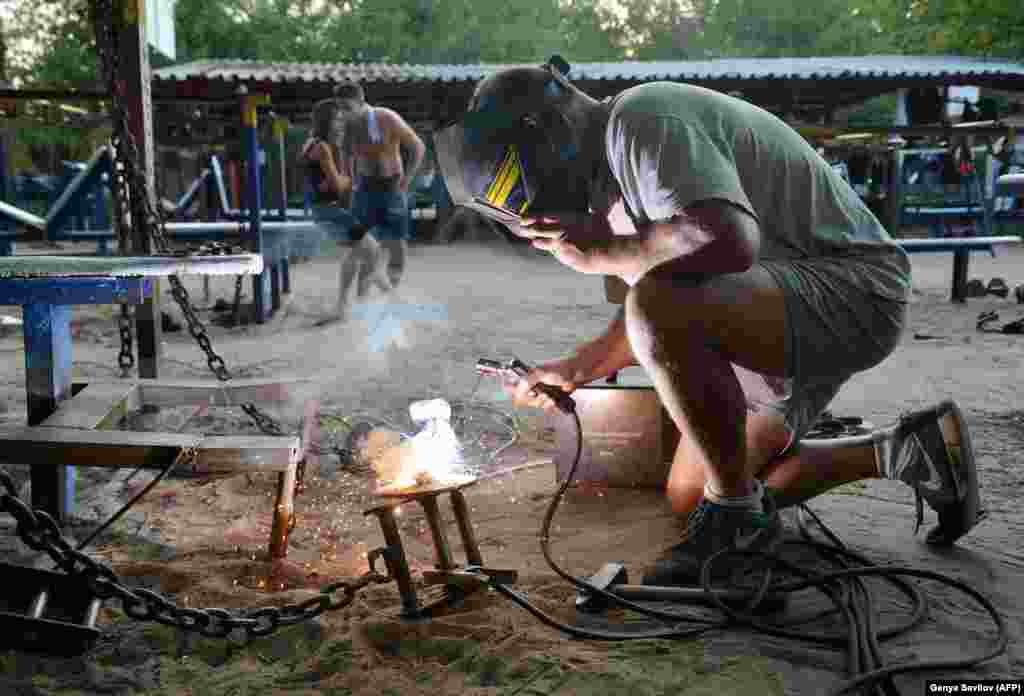 A worker repairing a dumbbell. Donations have enabled a small group of volunteers to install lights for night workouts, and repair the exercise machines.&nbsp;