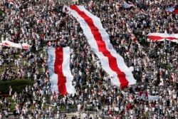 Прихильники білоруської опозиції зібралися з величезними біло-червоно-білими прапорами у центрі Мінська, 16 серпня 2020 року