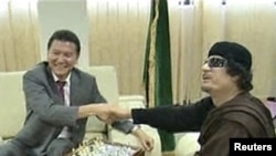 Муаммар Каддафи Дүниежүзілік шахмат федерациясының президенті Кирсан Илюмжановпен шахмат ойнап отыр. Триполи, 12 маусым 2011 жыл