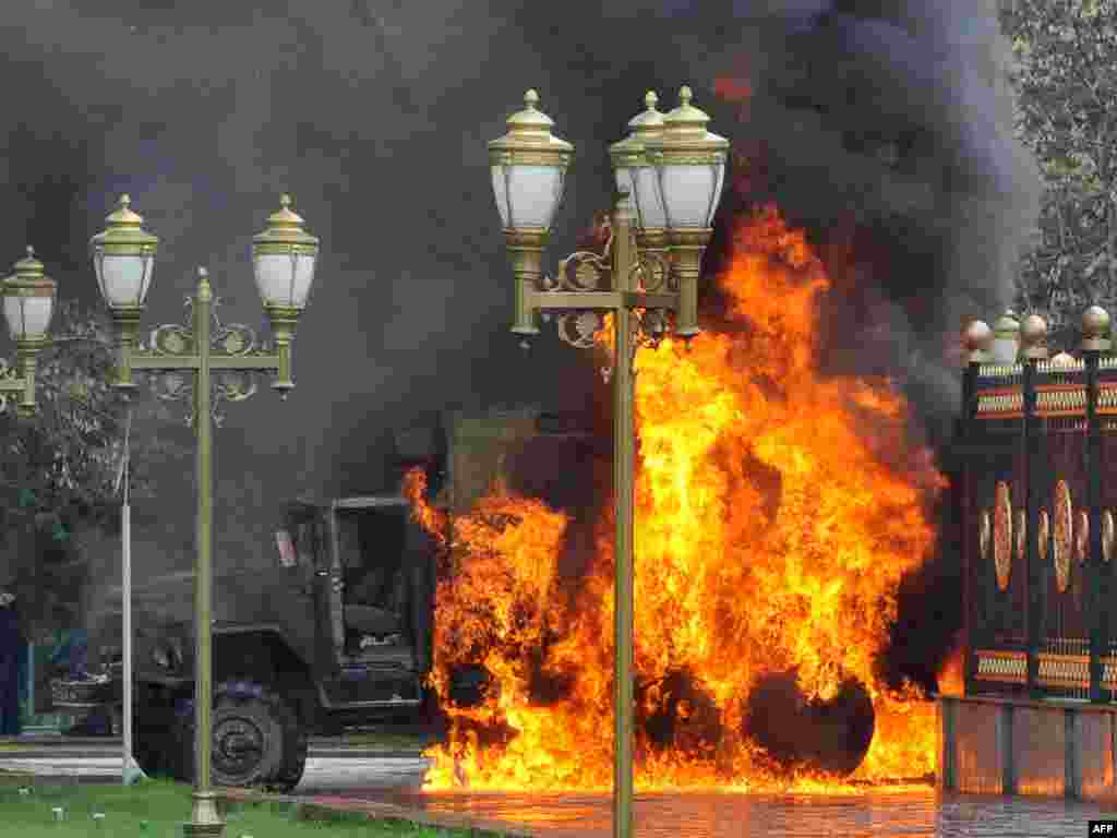 У ворот правительственного здания горит машина милиции. Бишкек, 7 апреля 2010 года.