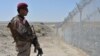 A Pakistani Army soldier stands guard along a border fence at the Afghan border near the Punjpai area of Quetta in Balochistan Province.