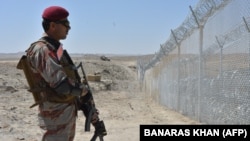 A Pakistani Army soldier stands guard along a border fence at the Afghan border near the Punjpai area of Quetta in Balochistan Province.