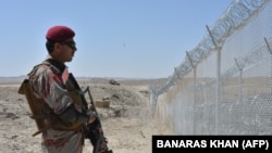 A Pakistani Army soldier stands guard along a border fence at the Afghan border near the Punjpai area of Quetta in Balochistan Province.