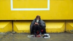 مرد کهن سال در ایام قرنطین در یکی از پیاده‌رو های شهر کابل نشسته تا از طریق بوت رنگ کردن پول به دست آورد.