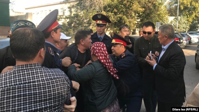 Полиция пытается доставить активиста в зал суда. Шымкент, 25 октября 2019 года.