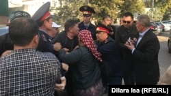 Полицейские пытаются принудительно доставить в суд жителя Шымкента Нуржана Мухамедова. 25 октября 2019 года.