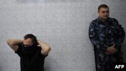 Полиция қызметкері азаматты психиатриялық сараптамаға әкеліп тұр. Мәскеу, 10 қазан 2011 жыл. (Көрнекі сурет)