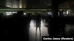 مسافران در فرودگاه بین‌المللی کاراکاس در حالی که برق فردوگاه قطع شده‌است