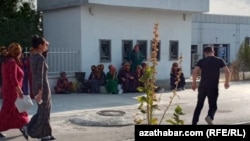 People wait for an ATM to start working in Baharden in August 2020.