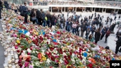 Adamlar Stokgolmdaky hüjümde pida bolanlaryň hatyrasyna "Sergels Torg" meýdançasyna gül goýýarlar.