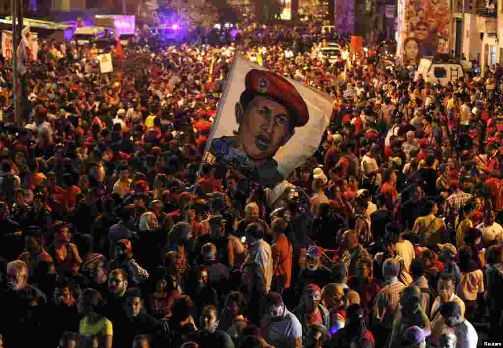 Supporters of Venezuela's President Hugo Chavez react to the announcement of his death outside the hospital where he was being treated in Caracas. Chavez died after a two-year battle with cancer. (Reuters/Carlos Garcia Rawlins)